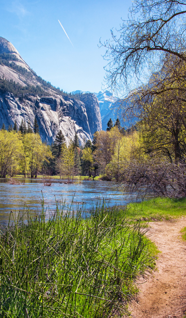 Тропинка у озера у подножия гор в парке