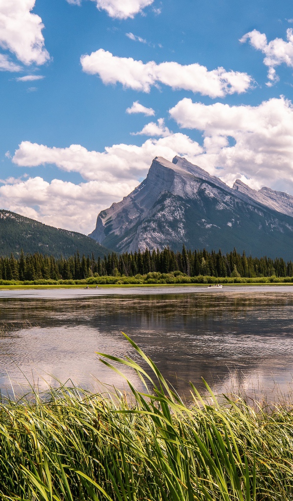 Красивое горное озеро под голубым небом с белыми облаками