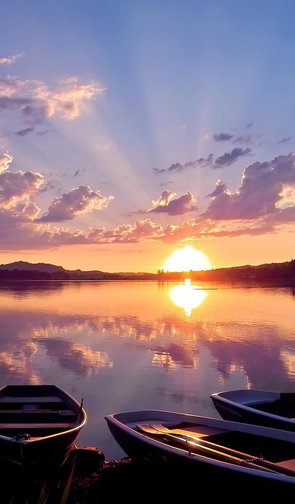 Лодки на берегу озера на закате солнца