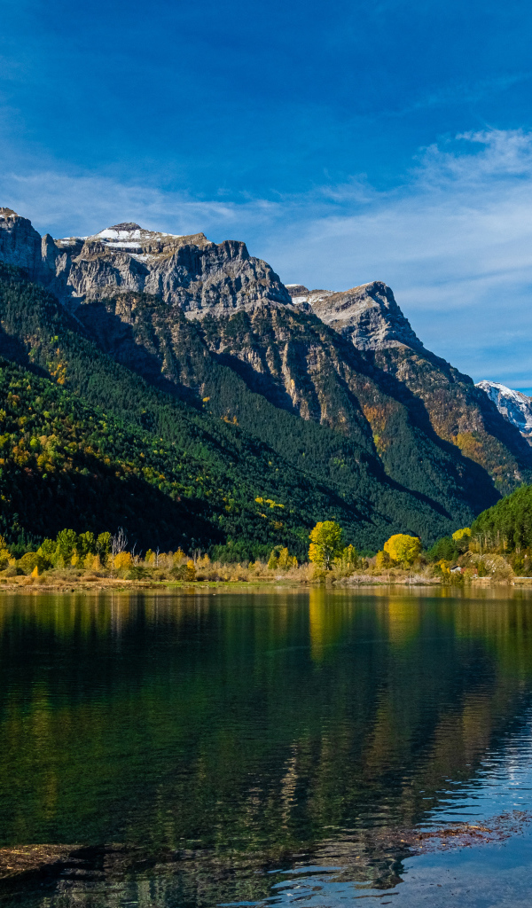 Холодная вода в чистом озере у горы под голубым небом