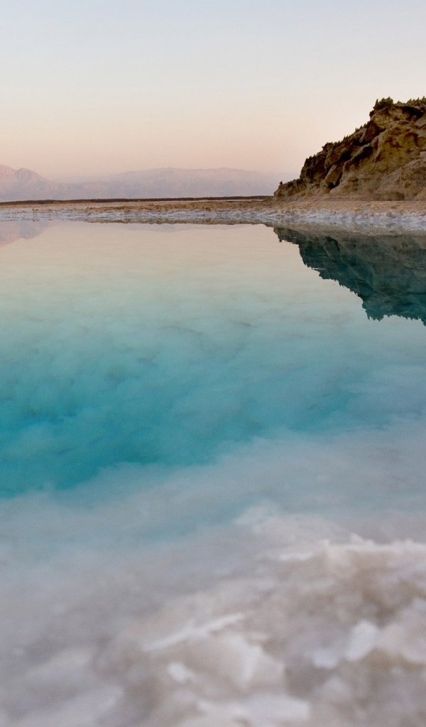 Покрытые льдом берега горного озера с голубой водой