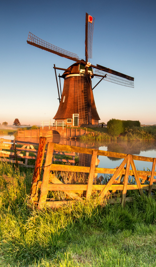 Старая мельница на берегу озера на ферме 