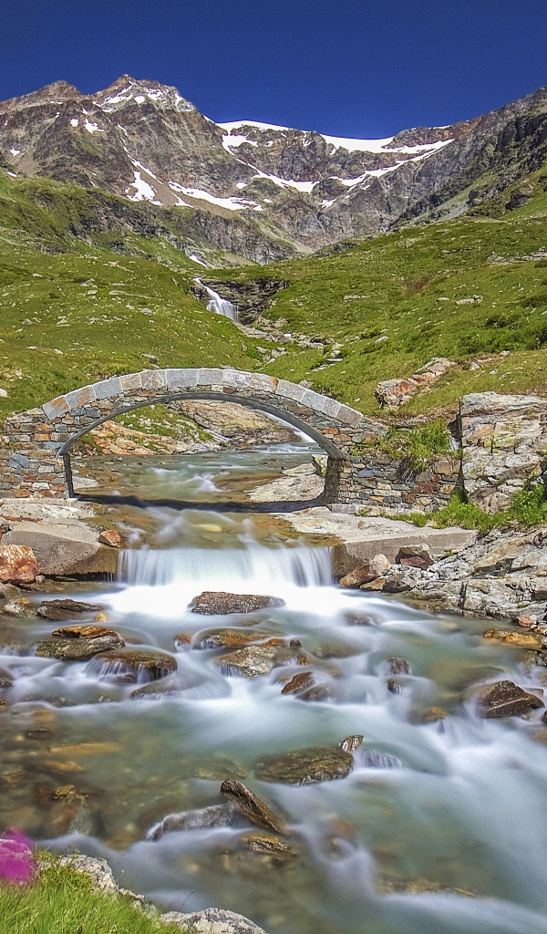 Маленький каменный мост через горную реку 