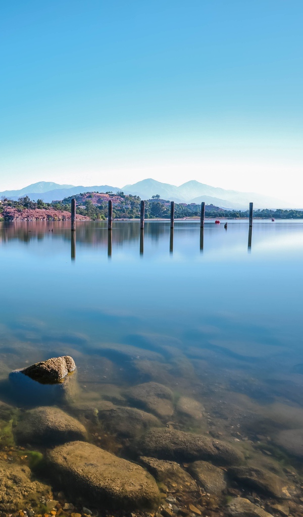 Камни в озере на фоне голубого неба