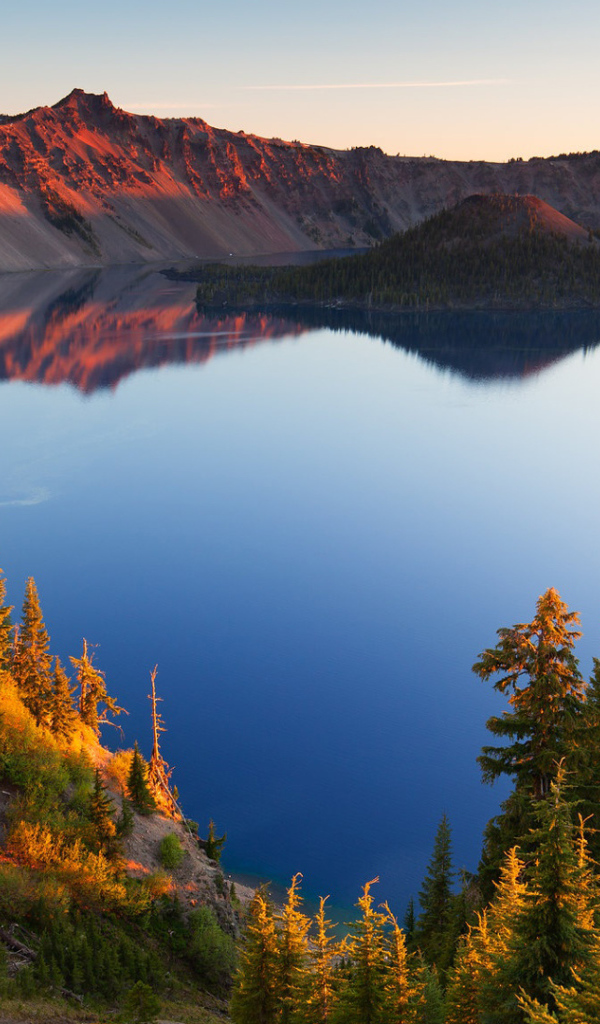 Небо отражается в горном озере в лучах солнца