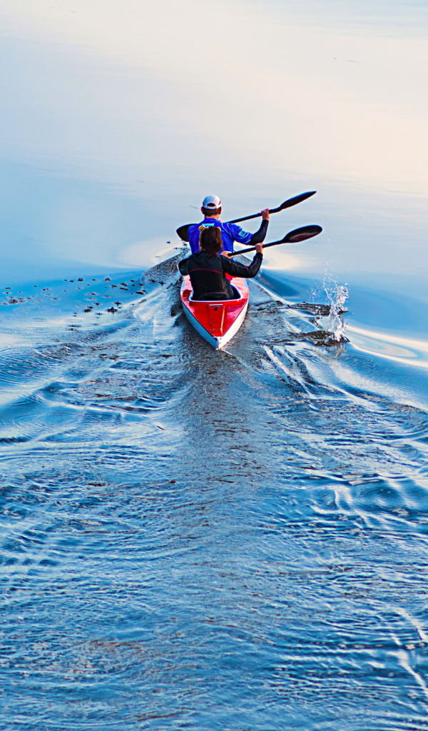 Два спортсмена на лодке плывут по реке 