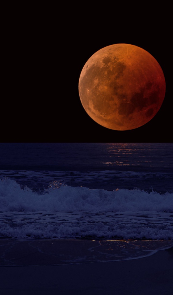 Большая красная луна в темном небе над морем