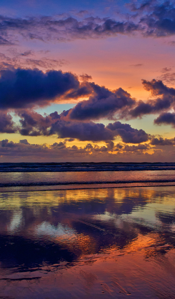 Black clouds reflected in sea water at sunset.