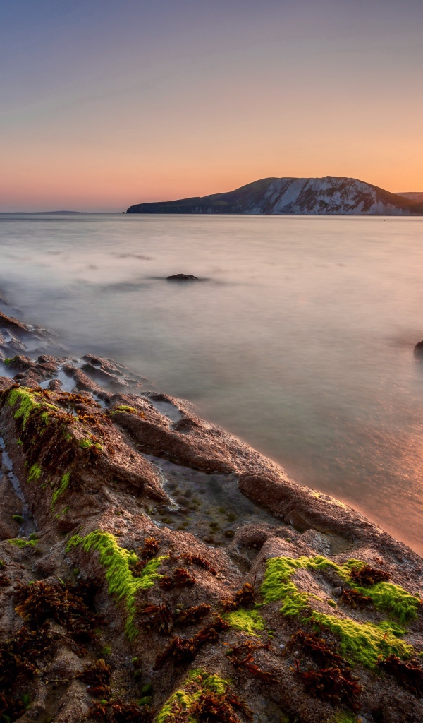 Спокойная вода в море с подводными камнями на закате 