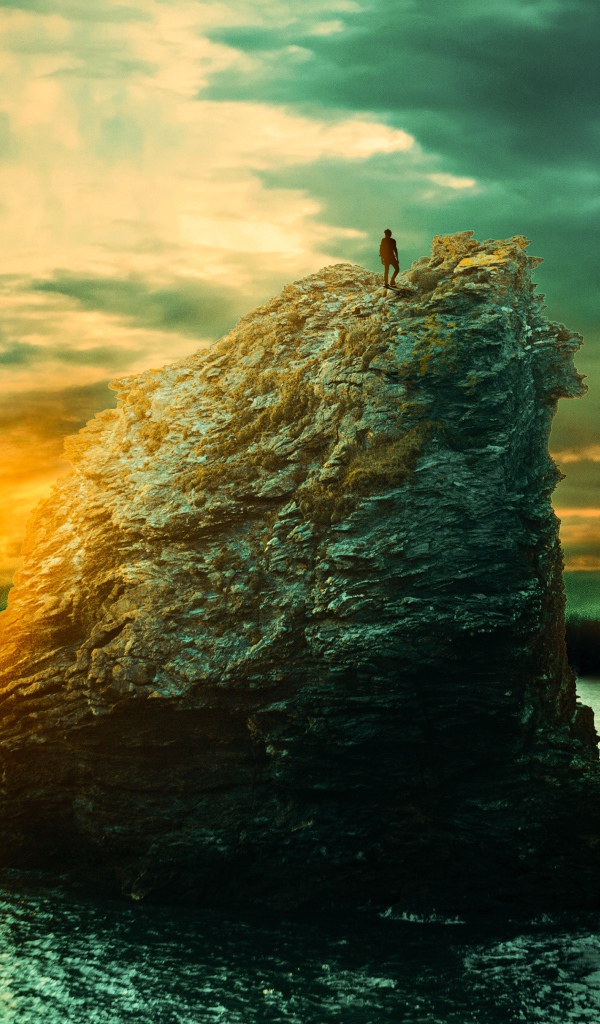 Скала в море на закате солнца