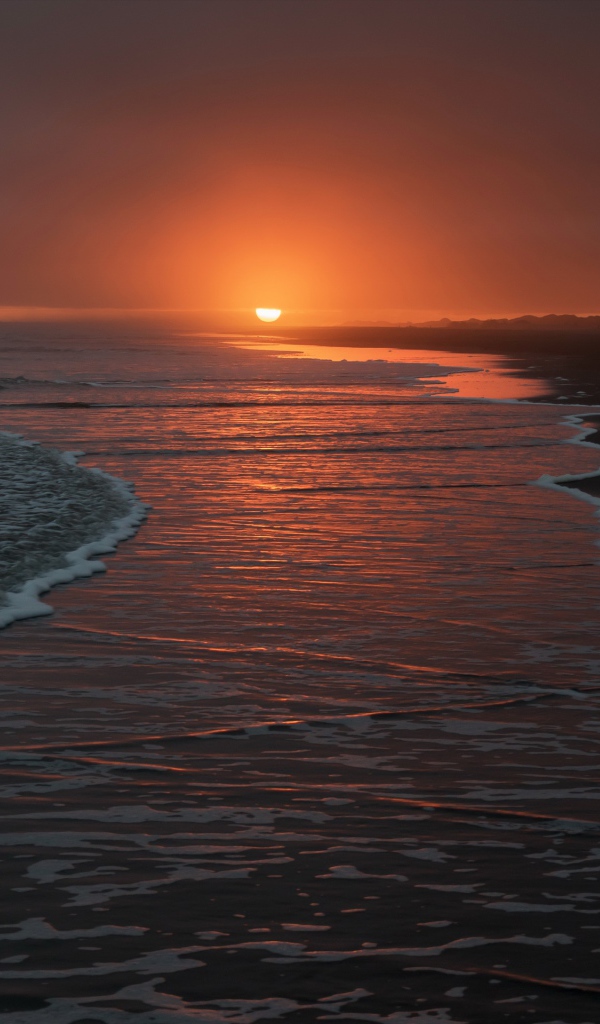 Тихие волны на берегу моря на закате