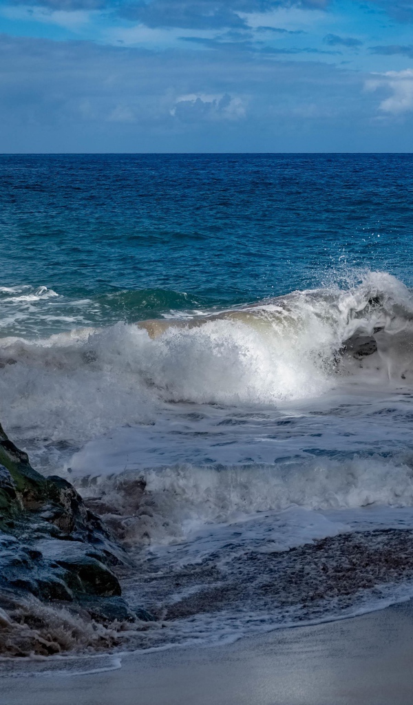 Бушующие белые волны в море у скал 