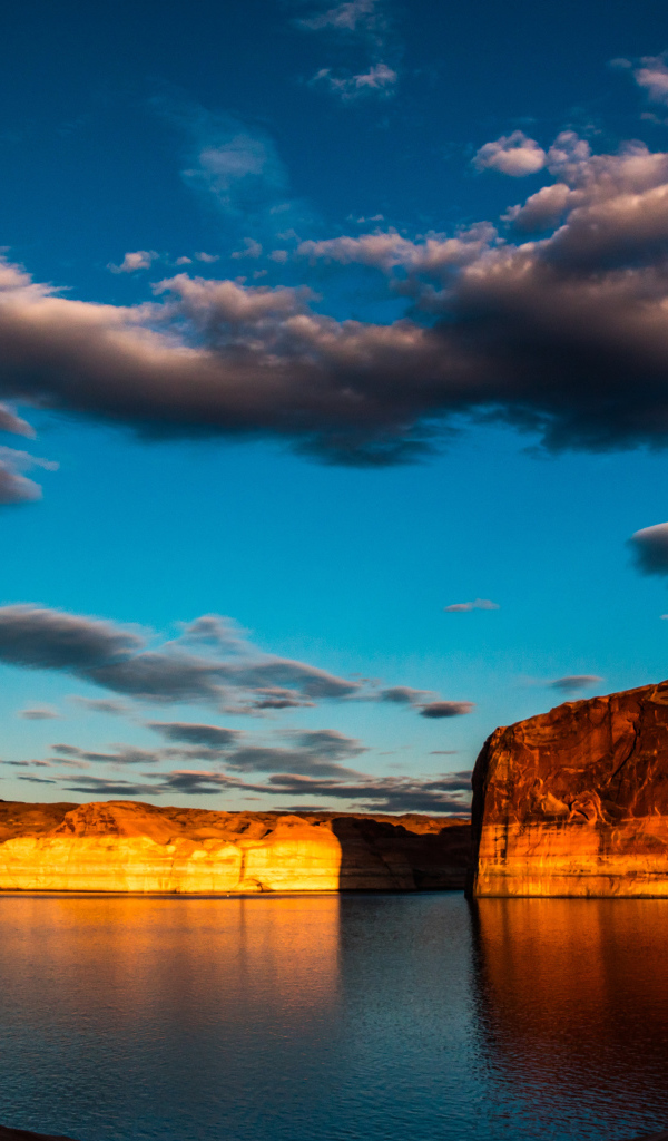 Скалы  в воде под голубым небом с облаками 