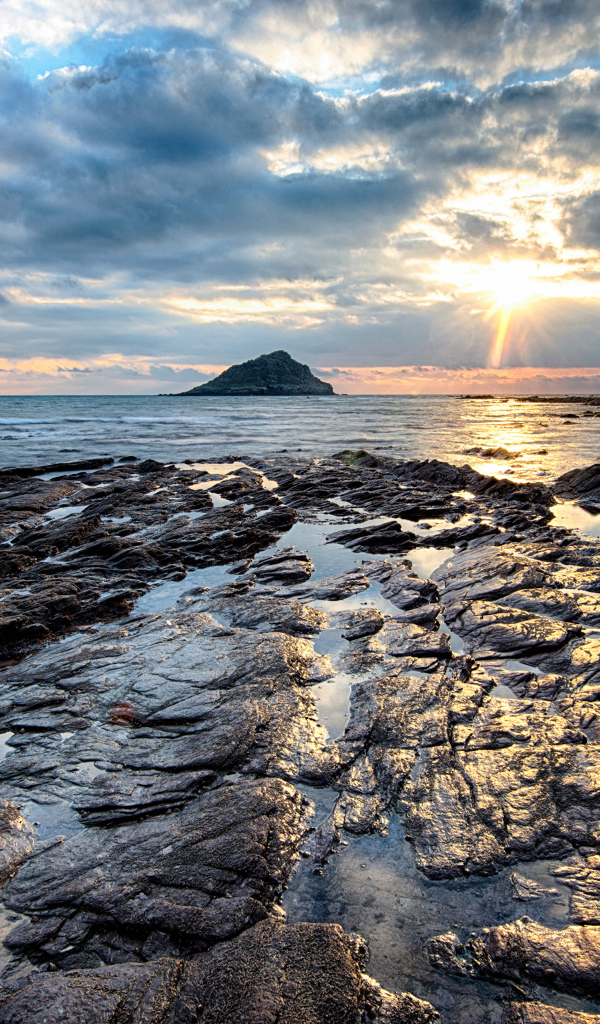 Каменный берег океана в лучах солнца