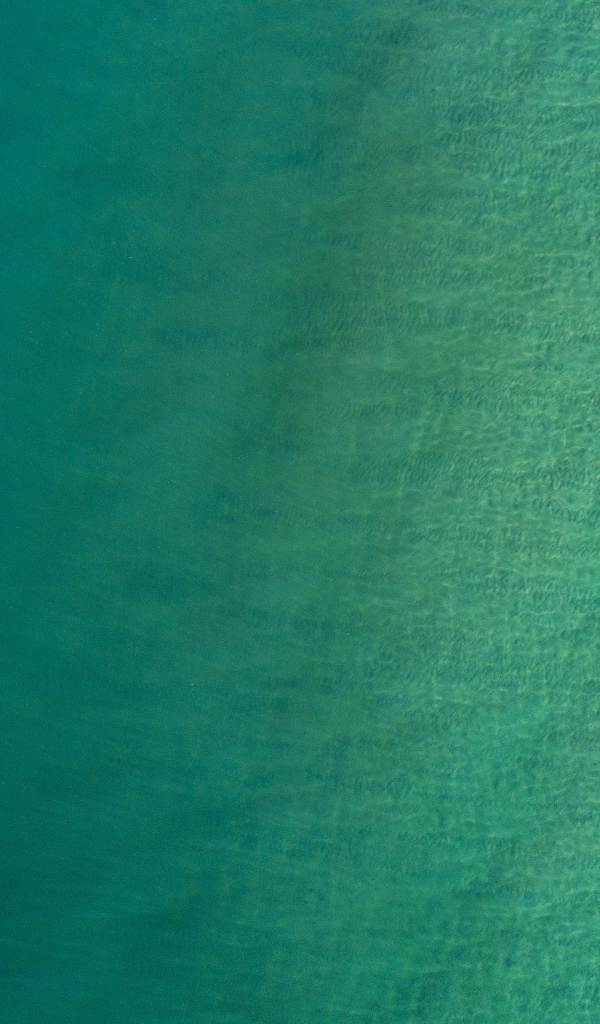 Вид сверху на спокойную голубую гладь океана