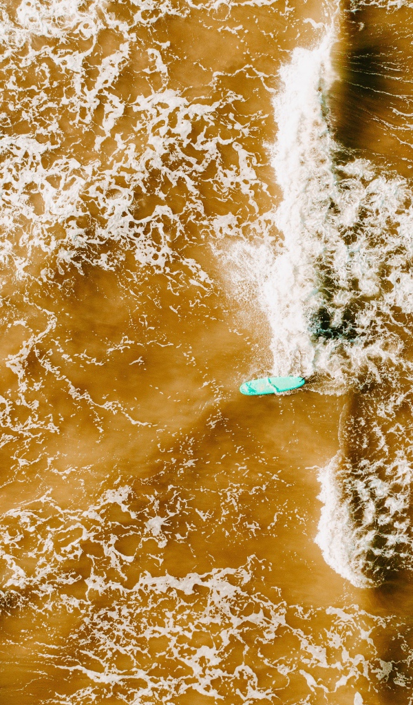 Белые волны на воде поднимают песок