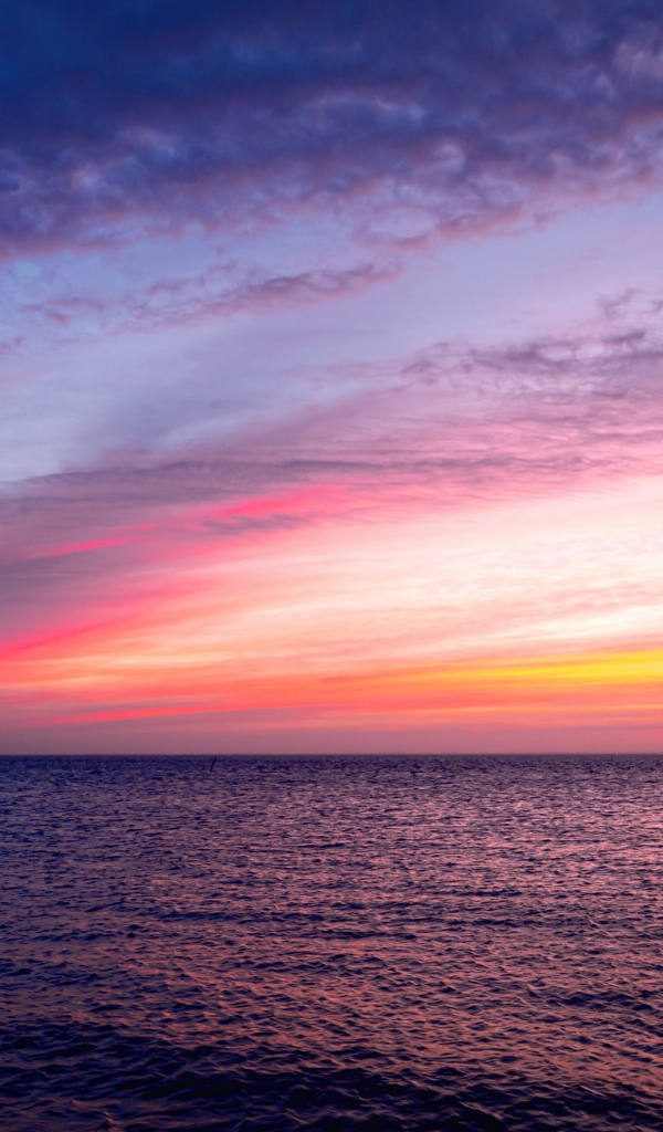 Красивый розовый закат в небе над тихим морем