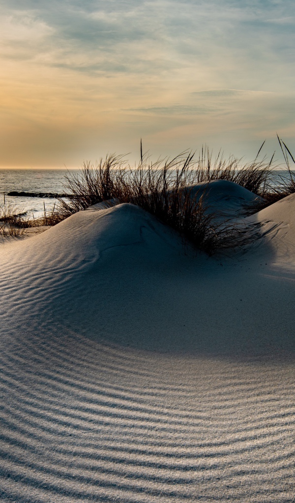 Горячий песок на берегу моря на закате 