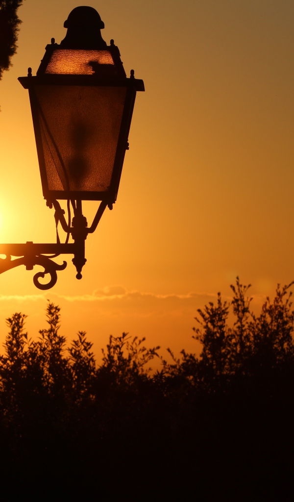 Фонарь на дома на закате солнца