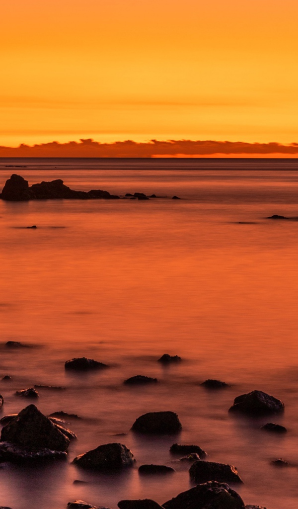 Камни на берегу моря на закате в сумерках 