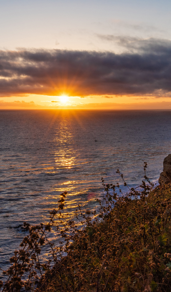 Вид на закат солнца в темных облаках в небе над морем 