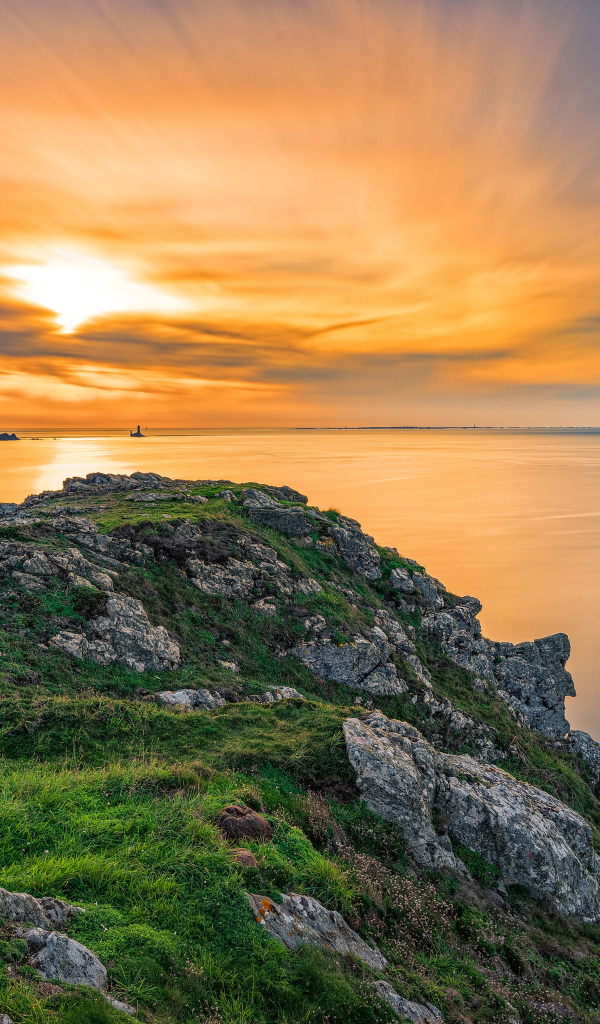 Вид со скалы на красивый закат в небе над спокойным морем 