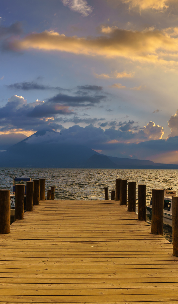 Деревянный мост в море на закате солнца 
