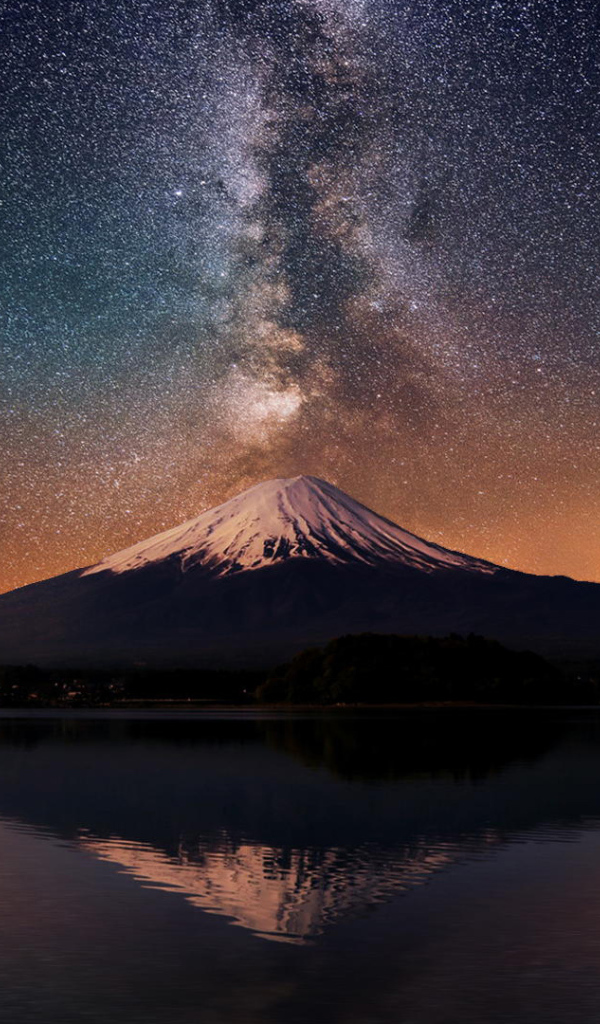 Заснеженная вершина вулкана под звездным небом