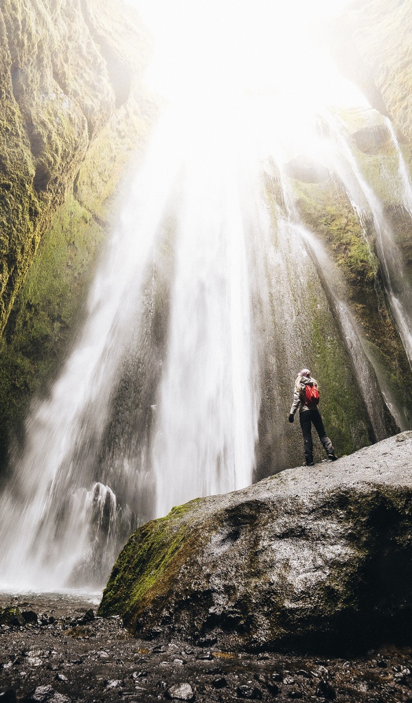 Быстрый водопад стекает между скал 