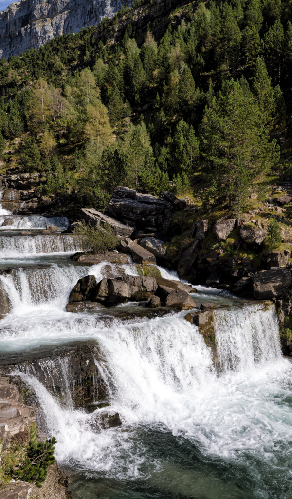 Красивые каскады водопада у скалы 