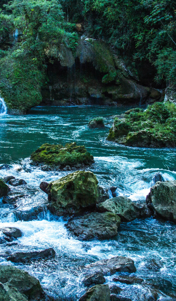 Голубая вода в водопаде стекает по камням 