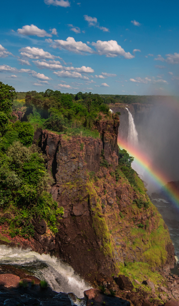 Радуга над водопадом на утесе 