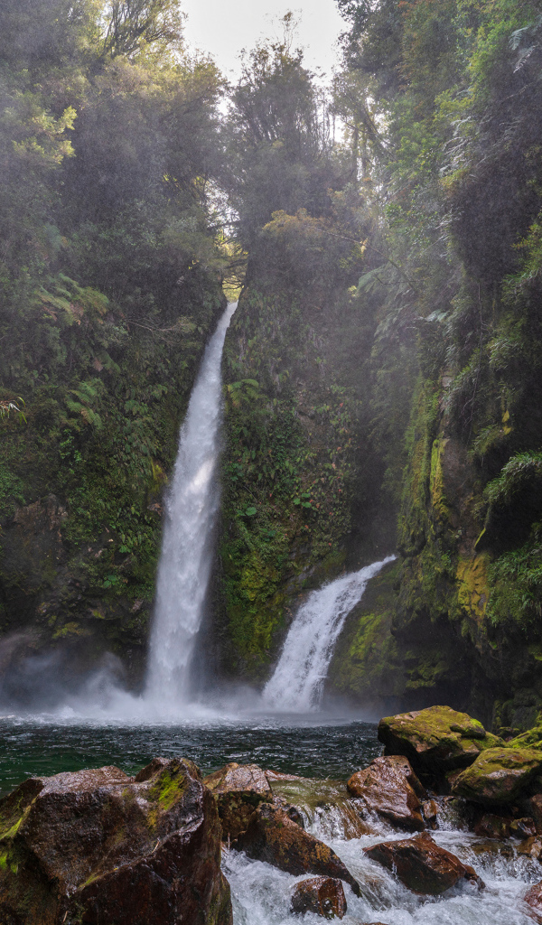 Водопад стекает со скалы в горную реку