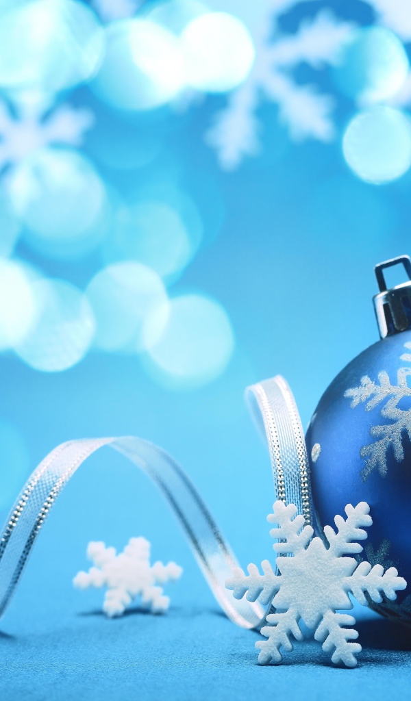 Красивый синий елочный шар с лентой и снежинками на Новый год 