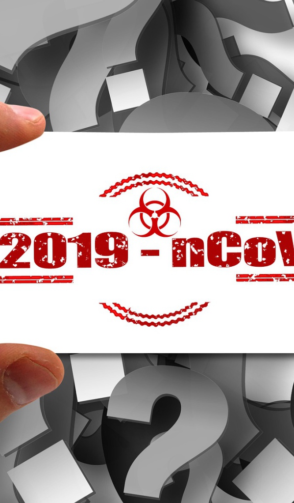 Табличка коронавирус covid-19 в руке на фоне знаков вопроса