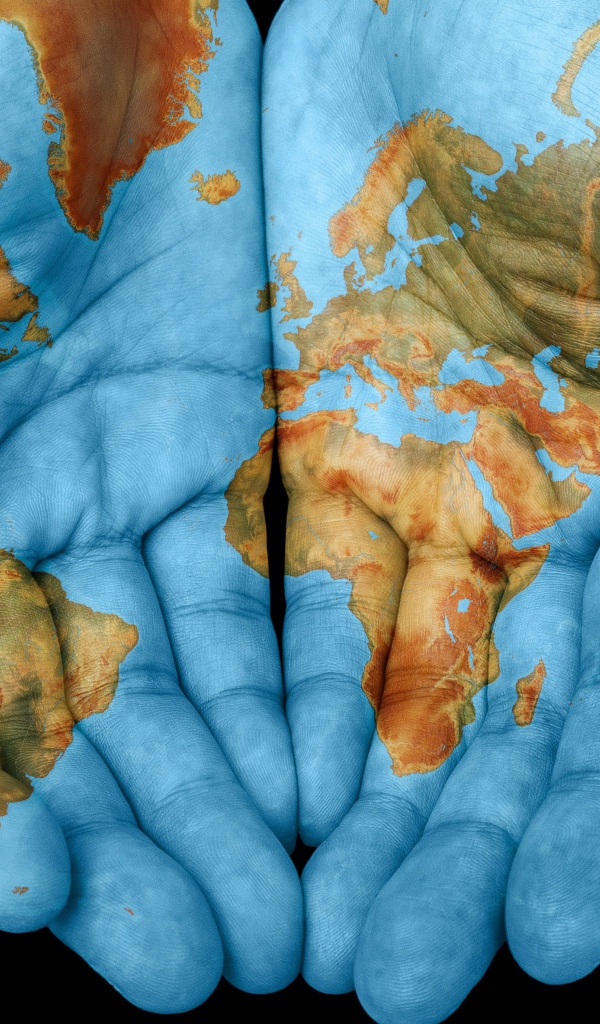 Руки с картой мира на черном фоне 