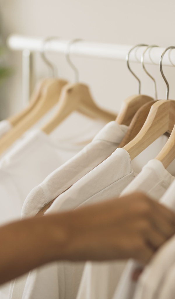 Много белых рубашек на вешалке