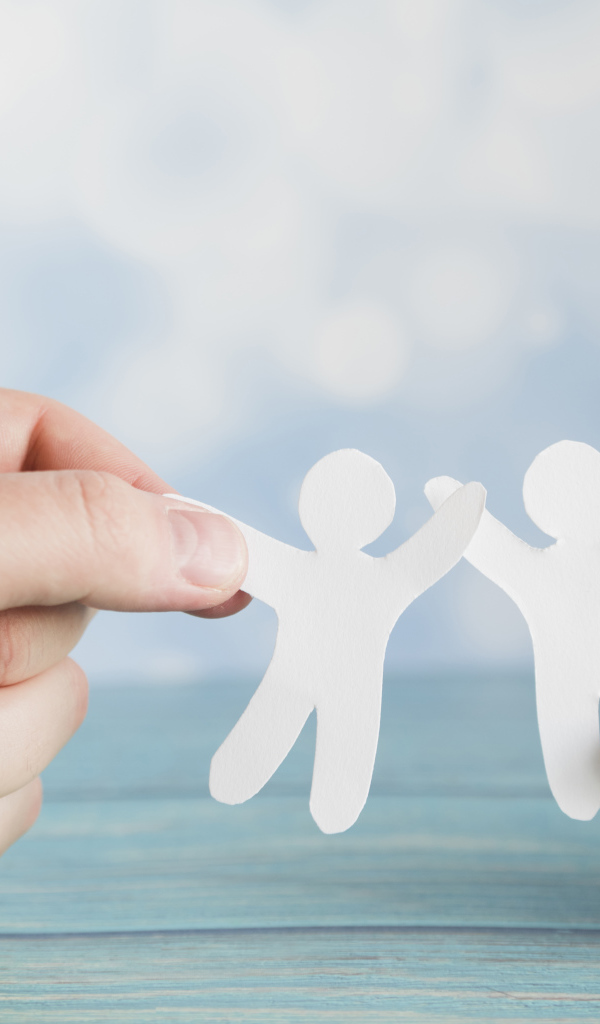 Два бумажных человечка в руках 