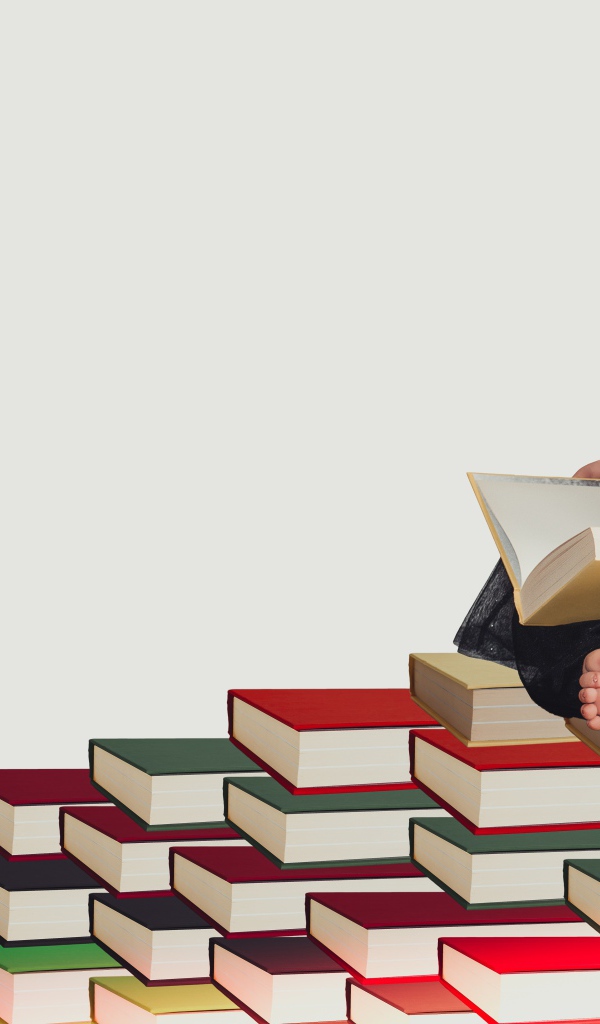Маленькая девочка сидит на горе книг 