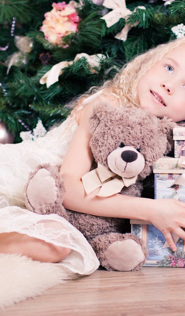 Красивая голубоглазая девочка с подарками у елки