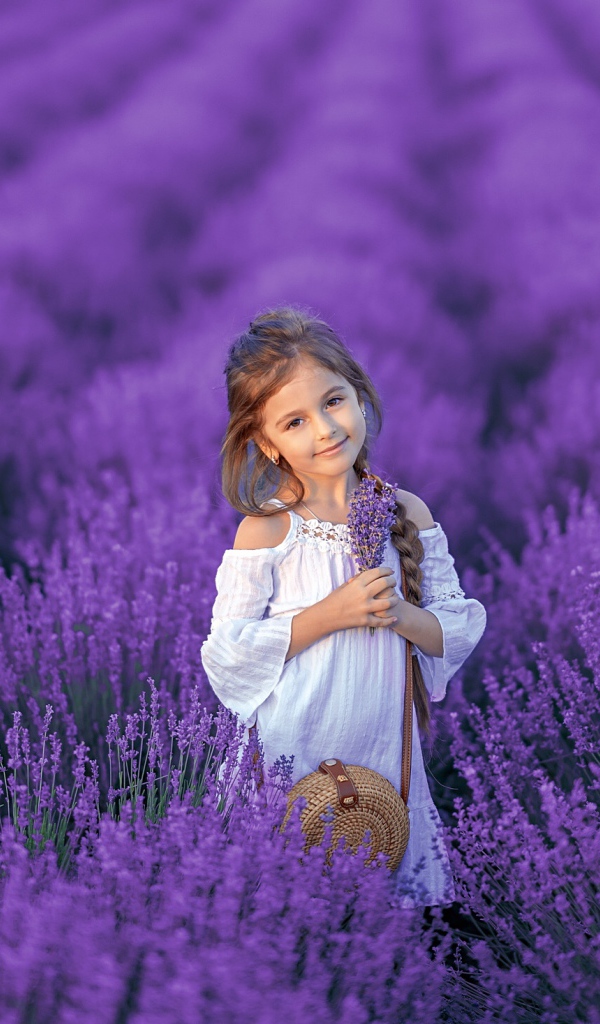 Красивая маленькая девочка на лавандовом поле 