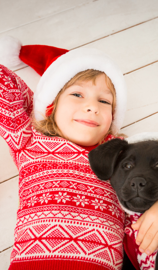 Милая девочка в новогоднем костюме на полу с собакой 