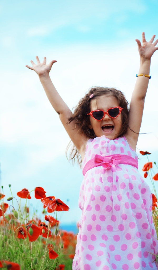 Счастливая маленькая девочка в платье на поле с маками