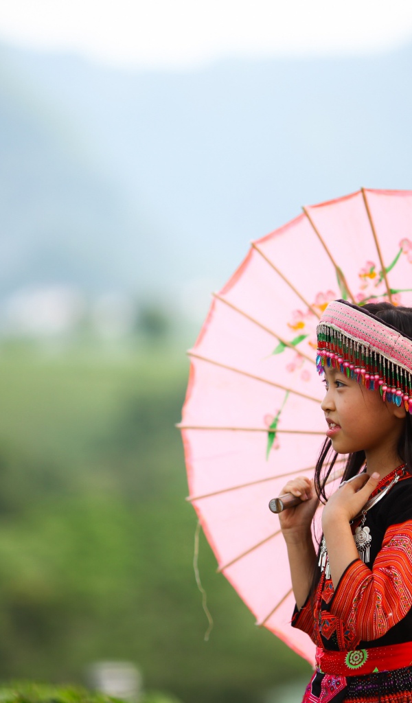 Маленькая девочка азиатка в розовым зонтом