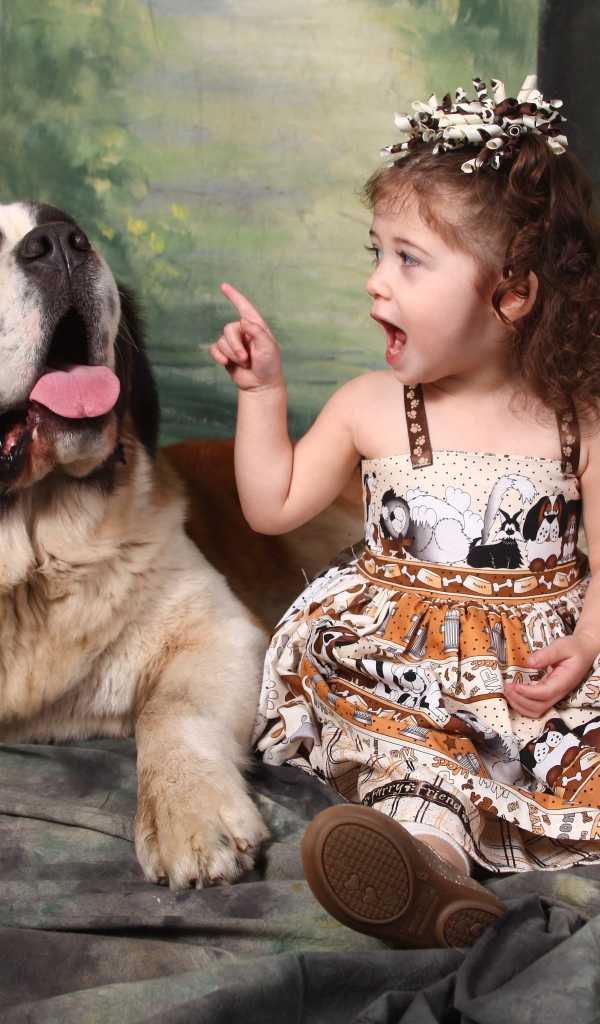 Маленькая красивая девочка с собакой породы сенбернар