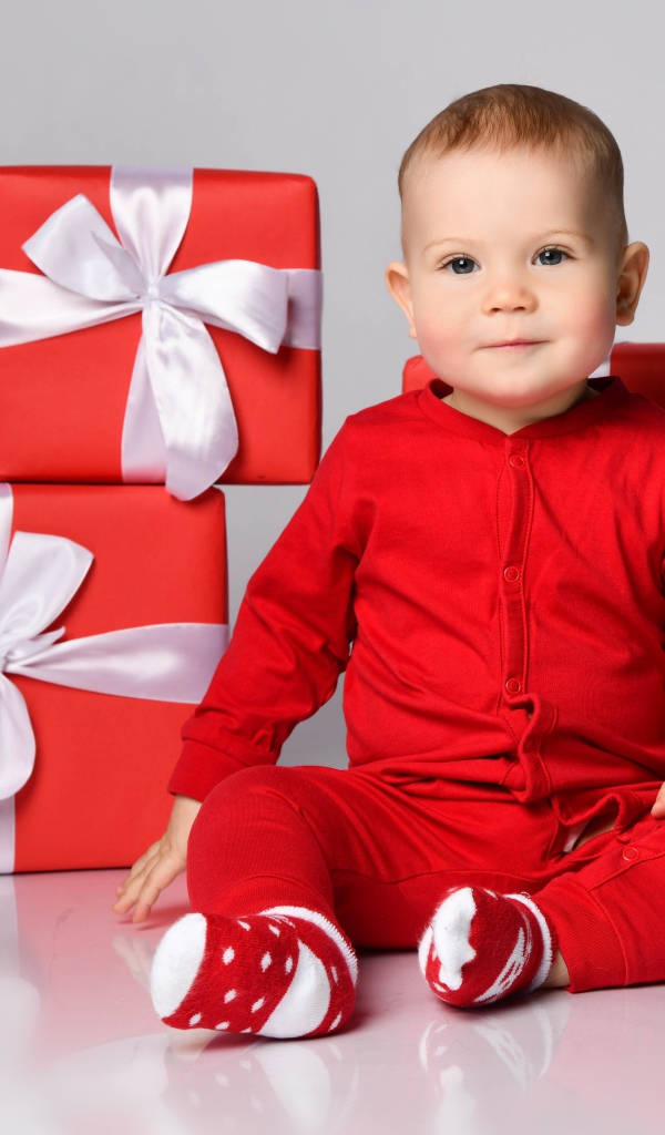 Маленький мальчик в красном костюме с подарками