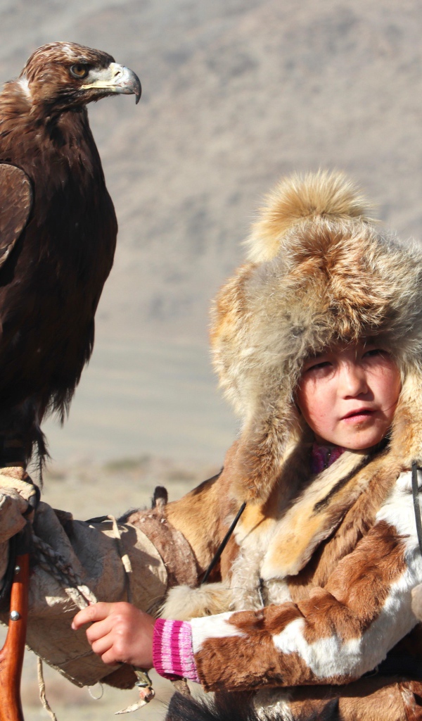 Маленький ребенок на охоте с хищным орлом