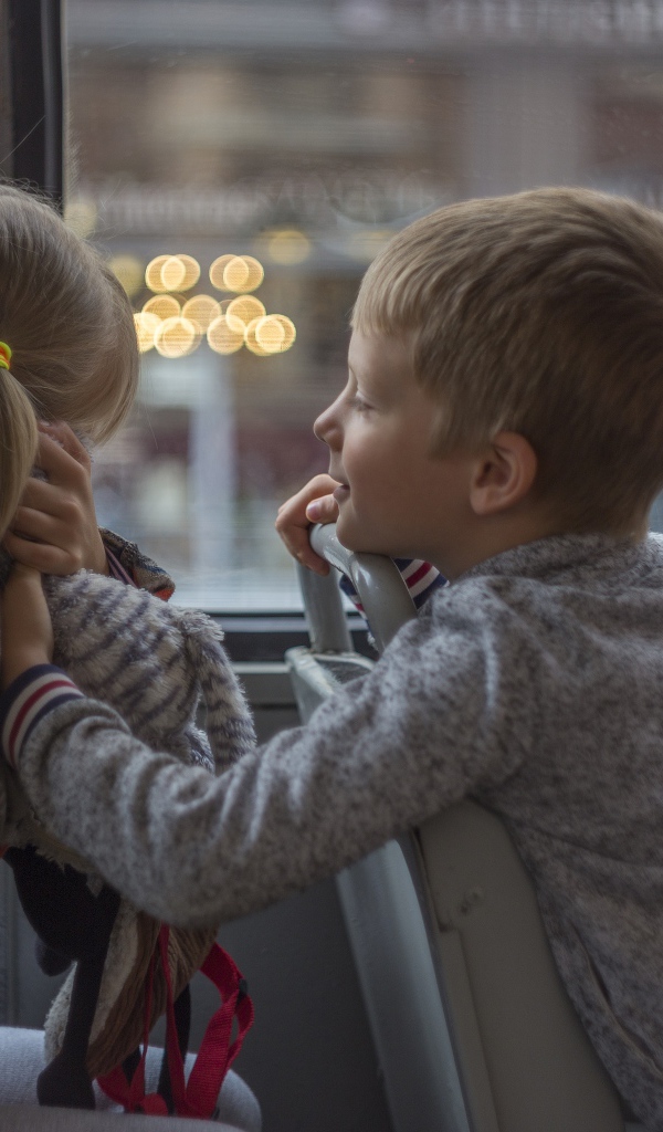 Маленькие девочка и мальчик сидят в автобусе 