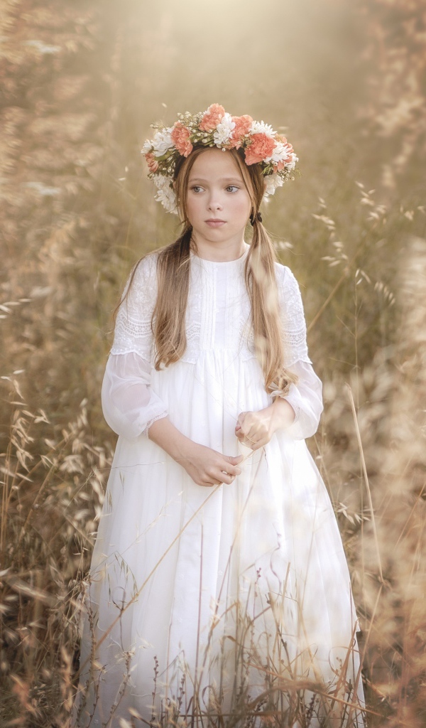 Маленькая девочка в белом платье с венком на голове 