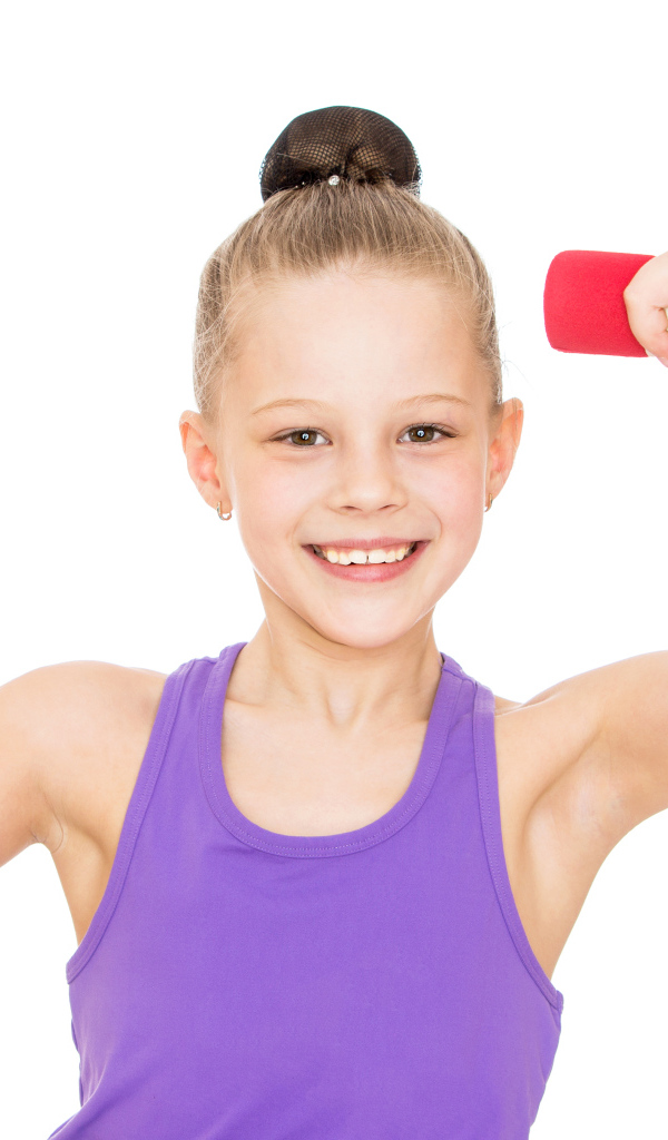 Маленькая девочка занимается с гантелей на белом фоне